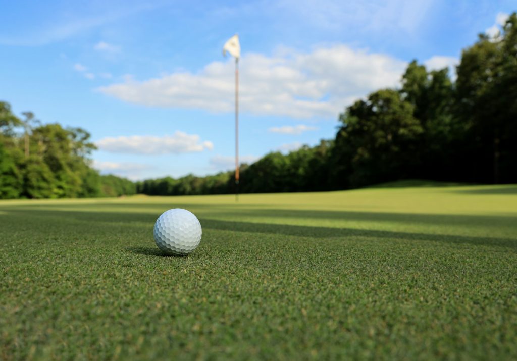 a golf ball on the green close to the flag